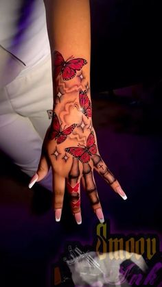 a woman's hand with butterfly tattoos on it