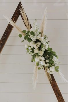 a wedding arch decorated with white flowers and greenery