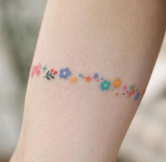 a close up of a person's leg with flowers on it and the word love written in small letters