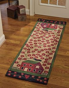 a rug on the floor in front of a door with a red house and flowers