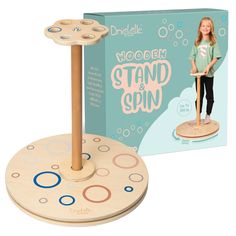 the wooden stand and spin toy is next to its box