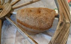 a close up of a wooden wheel with hay on the rim and wood spokes