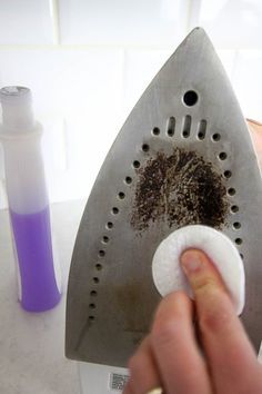 a hand is holding a grater with dirt on it and some other items nearby