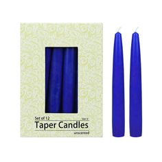 two blue candles sitting next to each other in front of a white box with the words taper candles written on it