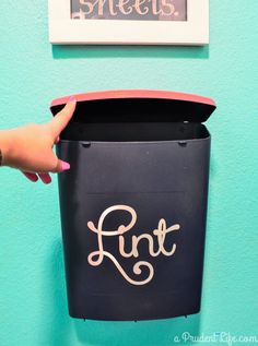 a hand is holding a black trash can with the word runt painted on it