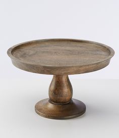 a wooden cake plate sitting on top of a table