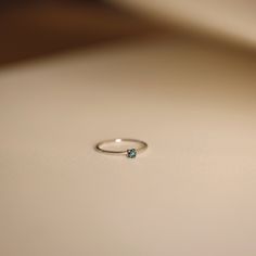 a diamond ring sitting on top of a white table next to a light brown wall