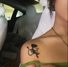 a woman with a tattoo on her shoulder sitting in a car