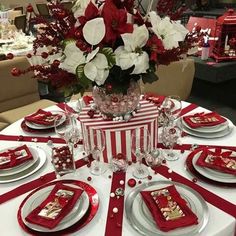 a table set for christmas with red and white decorations