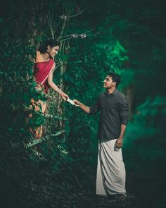 a man and woman holding hands in the woods