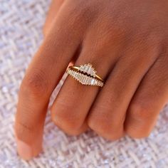 a close up of a person's hand with a gold ring on their finger