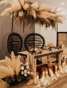 a long table with candles and flowers on it is surrounded by tall pamodia