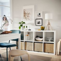 a white table with baskets and pictures on the wall