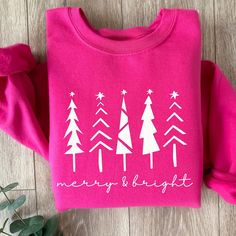 This Merry and Bright sweatshirt in Hot Pink is perfect for this holiday season whether you are cozying up with a good book or a holiday movie, going to a holiday function or getting your Christmas tree, this cozy sweatshirt is a great choice and makes a beautiful gift too. Check out the rest of our store here--> https://coastcountrydesign.etsy.com These garments are made from polyester and cotton. This combination helps designs come out looking fresh and beautiful. The collar is ribbed knit, so it retains its shape even after washing. There are no itchy side seams on these sweaters.  .: 50% cotton, 50% polyester (fiber content may vary for different colors) .: Medium-heavy fabric (8.0 oz/yd² (271 g/m .: Classic fit .: Tear-away label .: Runs true to size CARE INSTRUCTIONS:  * Turn garment Puff Vinyl Shirt Ideas Christmas, Christmas Sweat Shirts, Pink Christmas Sweatshirt, Cricut Christmas Sweatshirts, Cute Christmas Sweatshirts, Pink Christmas Sweater, Merry Sweatshirt, Merry And Bright Christmas