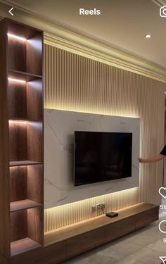 a living room with built in bookshelves and a flat screen tv mounted on the wall