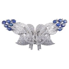 Impressive platinum brooch, converts into two clips, set with blue sapphires and approx. 14 carats in H/VS-SI diamonds. Brooch measures 3.25" x 1.5', converts into two clips - each measuring 1 7/8" x 1.5". Weight of the piece - 45.8 grams. Formal Sapphire Diamond Brooches, Formal Sapphire Diamond Brooch, Elegant Sapphire Diamond Brooches, Luxury Sapphire Brooch Jewelry, Vintage Blue Diamond Brooches, Blue Gems, Sapphire Diamond, Style Retro, Blue Sapphire