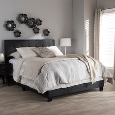 a bed sitting in a bedroom on top of a hard wood floor next to a window