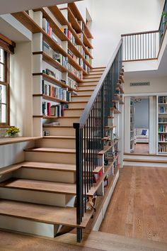 there is a stair case with books on the shelves next to it in this house