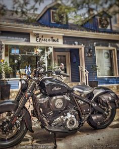 a black motorcycle parked in front of a blue building with a sign that says effie's town