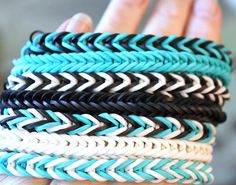 a person holding several different colored bracelets in their hands