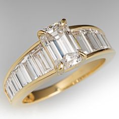 This endlessly shiny ring is centered with one (1) emerald cut diamond set into a four-prong setting. The shoulders of the ring are each accented with six (6) channel set, trapezoid step cut diamonds. The ring measures 7.9mm at the top, rises 5.6mm above the finger, tapering to 1.9mm wide and 0.9mm thick at the base of the shank. The piece is crafted in 18k yellow gold and is currently a size 5 5/8ths. Due to the design of this ring, resizing is not recommended but an insert can be used to reduce the size. Channel Set Engagement Ring, Gold Emerald Cut Engagement Ring, Antique Engagement Rings Sapphire, Engagement Rings Channel Set, Estate Jewelry Rings, Shiny Rings, Emerald Cut Diamond Ring, Art Deco Wedding Rings, Emerald Cut Rings