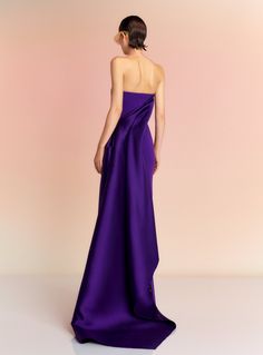 a woman in a purple dress looking back