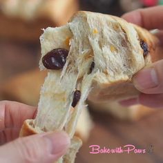 a person holding a piece of bread with raisins and olives on it