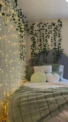 a bed that has some lights on the headboard and pillows in front of it