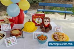 a table topped with lots of food and balloons