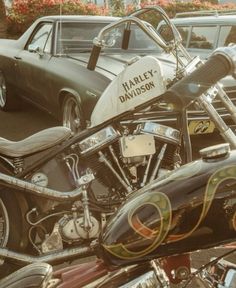 a harley davidson motorcycle parked in a parking lot next to other motorcycles and cars on the street