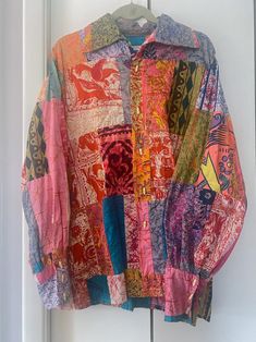 a multicolored shirt hanging on a white door