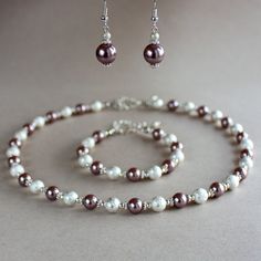 A contemporary 3-piece jewellery set featuring quality faux pearls in unique rosy brown/bronze colour and bright silver plated stardust beads. Perfect for any occasion, weddings and parties or as a gift. Set contains collar necklace, beaded bracelet and a pair of drop earrings. Organza gift bag included!  Please note that although I take a great care to keep the colours on the photographs as close to reality as possible, they may look slightly different on different monitors. Materials used: Gla Formal Pearl Jewelry With Silver Beads, Handmade Adjustable Rose Gold Jewelry, Adjustable Handmade Rose Gold Jewelry, Pearl Jewelry With Silver Beads, Elegant Sterling Silver Jewelry With Silver Beads, Formal Jewelry With Silver Beads, Elegant Silver Jewelry With Polished Beads, Elegant Adjustable Metal Jewelry, Silver Beads Metal Jewelry