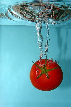 a tomato being dropped into the water