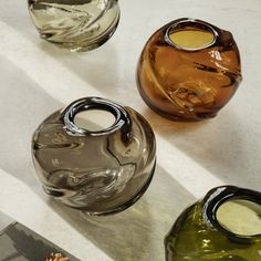 three glass vases sitting on top of a table