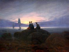 two people sitting on rocks looking out at the ocean with a lighthouse in the background