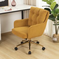 a yellow office chair sitting on top of a wooden floor next to a white desk