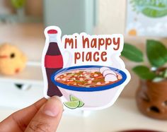 someone holding up a sticker with a bowl of soup in it