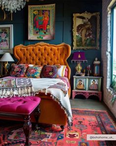 a bedroom with an orange bed, pink bench and pictures on the wall above it