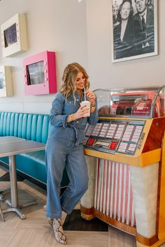 a woman standing next to a juke machine