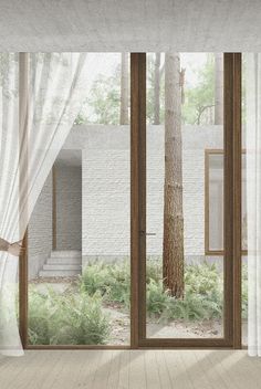 an open window with white curtains and a tree in the middle of it on a wooden floor next to a brick wall