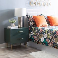 a bed room with a neatly made bed and a night stand on the side table