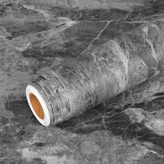 a roll of toilet paper sitting on top of a marble floor