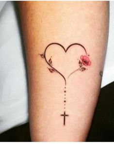 a cross and heart tattoo on the leg