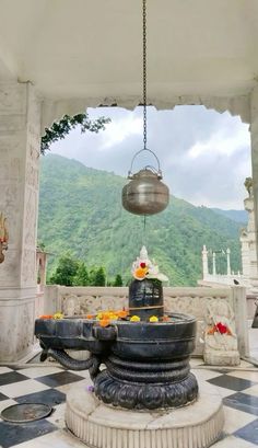 an outdoor shrine with a bell hanging from it's ceiling