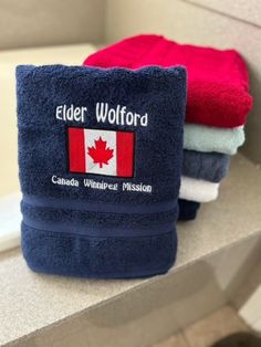 towels are sitting on the edge of a bathtub in front of a mirror that says elder wofford