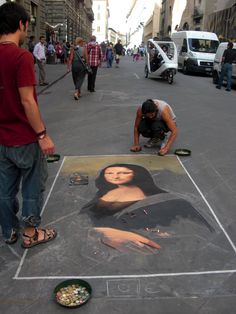 a man is drawing a portrait on the sidewalk