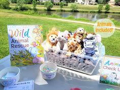 stuffed animals are sitting in a basket on a table with an animal rescue sign and greeting cards