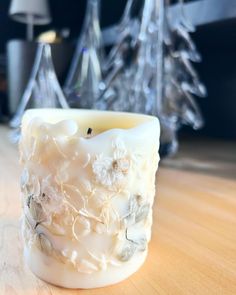 a white candle sitting on top of a wooden table