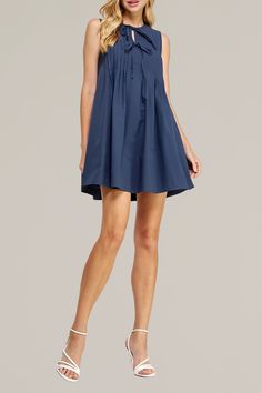 step out in style with this navy pintuck tie front poplin mini dress. this dress is designed with intricate pintuck detailing and a babydoll silhouette. the tie front adds a touch of sophistication, while the crisp poplin fabric ensures a comfortable, lightweight fit. perfect for any occasion, this mini dress combines classic design with modern elegance. pair it with your favorite accessories for a chic, on-trend outfit that’s sure to turn heads. 100% cotton side pockets hand wash cold | hang to Mini Dress With Pleated Waist For Daywear, Pleated Cotton Mini Dress For Daywear, Cotton Pleated Mini Dress For Daywear, Elegant Poplin Summer Dress, Elegant Summer Poplin Dress, Elegant Poplin Dress For Summer, Chic Summer Poplin Dress, Navy Ruffled Mini Dress, Mini Tunic Dress