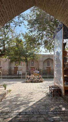 an outdoor area with tables and chairs under a tree